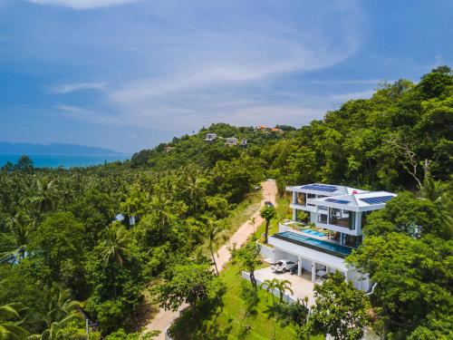 an aerial view of a house on a hill with trees at Villa Tosti in Ban Bang Po