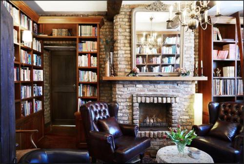 a living room with two leather chairs and a fireplace at Artagnan in Maastricht