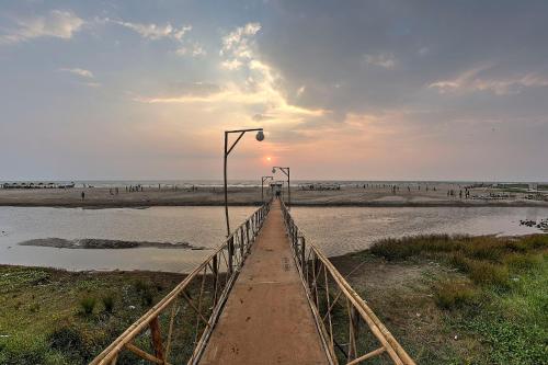 a bridge over a body of water with a beach at Beach Street Eco Resort - Mandrem in Mandrem