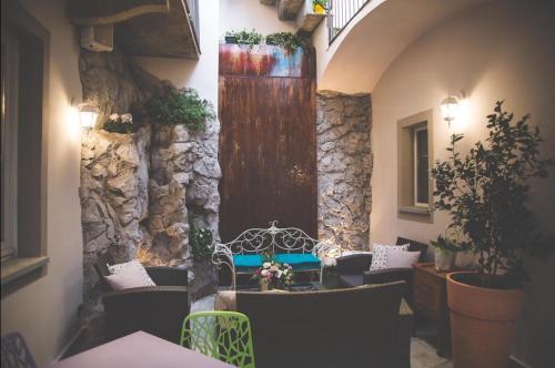 a restaurant with tables and chairs and a stone wall at Cantina del Convento Maison in Chieri
