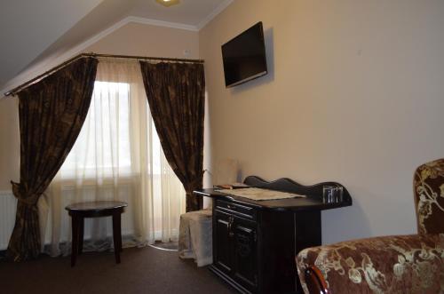 a living room with a desk and a window at Golden Palace in Dubove