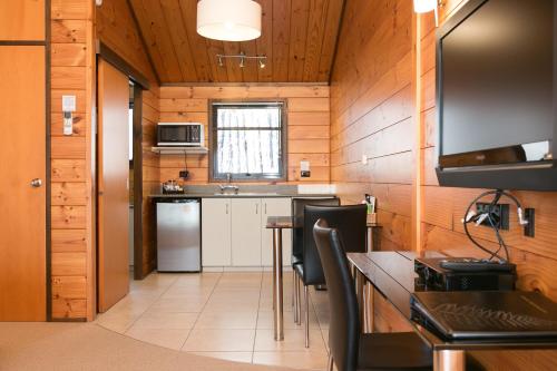 - une cuisine avec des murs en bois, une table et des chaises dans l'établissement Lockwood Manor Motel, à New Plymouth