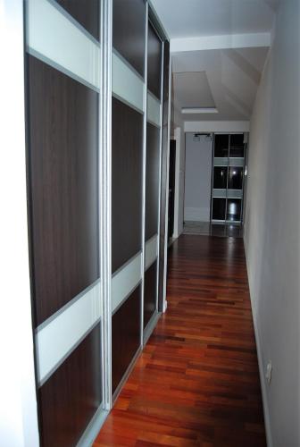 a hallway with sliding glass doors and wood floors at 3-Pokojowy Apartament Villa Park - Top Location in Olsztyn