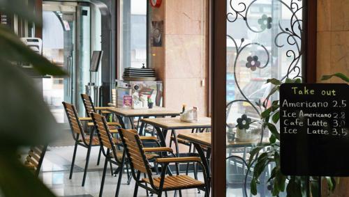 a row of tables and chairs in a restaurant at Insadong Crown Hotel in Seoul