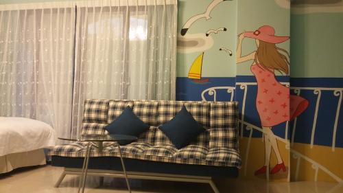 a bedroom with a mural of a woman on the wall at Aegean Sea Baoli B&B in Taitung City