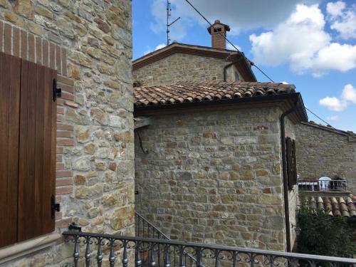 an old brick building with a wooden door at Appartamenti e Camere Il Poggio di D'Angeli Lidia in Auditore