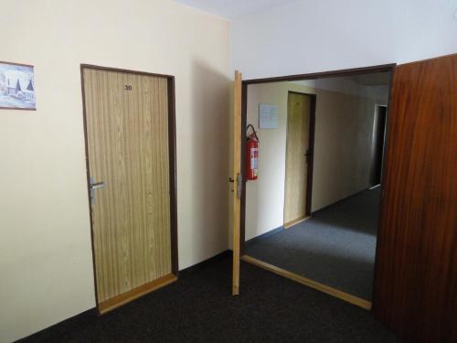 an empty hallway with a mirror and a fire extinguisher at Penzion Horalka in Hlinsko