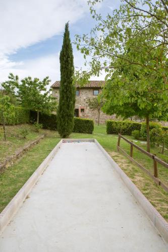 a walkway in front of a house with a tree at Podere Il Tigliolo in Castiglione dʼOrcia