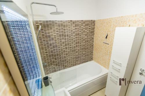 a bathroom with a shower and a white bath tub at Cozy Apartment - Palas in Iaşi