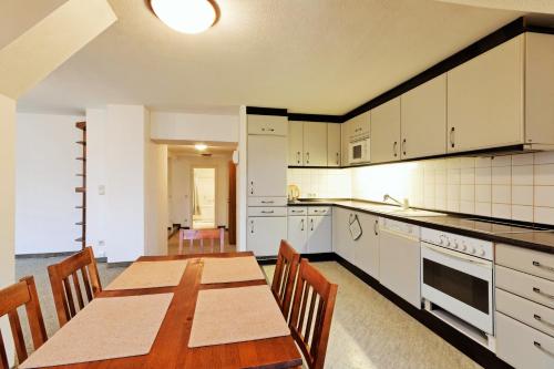 an empty kitchen with a wooden table and chairs at Penzion Dvořákova in Brno