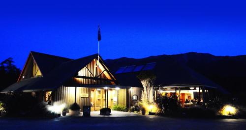 um edifício com uma bandeira no topo à noite em Alpine Lodge em Saint Arnaud