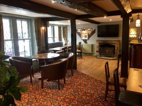 a living room with tables and chairs and a fireplace at The Talbot Hotel in Cleobury Mortimer