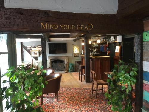 a living room with a sign that reads mind your head at The Talbot Hotel in Cleobury Mortimer