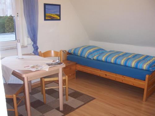 Kleines Zimmer mit einem Bett und einem Tisch in der Unterkunft Haus am Roseneck in Lüneburg