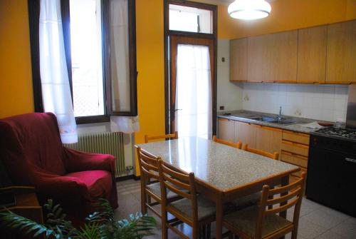 een keuken met een tafel, een stoel en een tafel bij Casa Vacanze Vedelago in Istrana