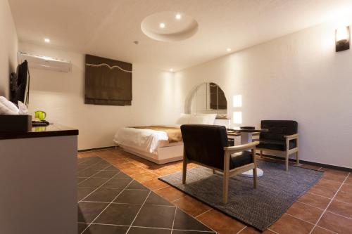 a bedroom with a bed and a table and chairs at Hotel Leaders in Seoul