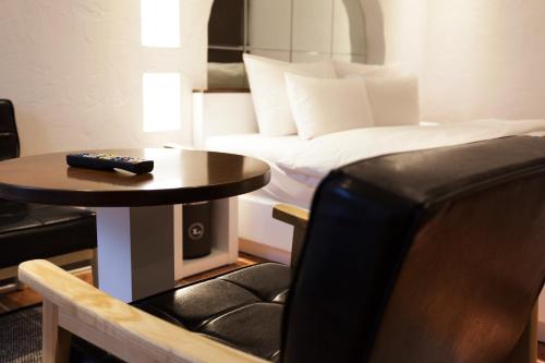 a room with a bed and a table with a remote control at Hotel Leaders in Seoul