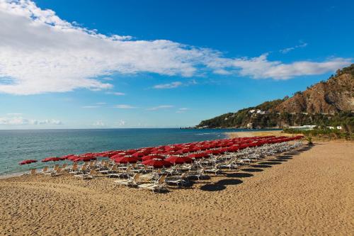 a line of chairs and umbrellas on a beach at Club Esse Sunbeach in Squillace