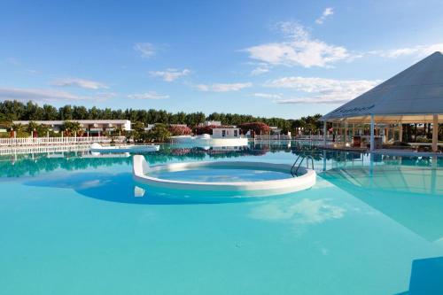 a pool at a resort with blue water at Club Esse Sunbeach in Squillace
