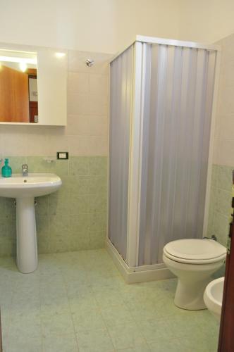 a bathroom with a shower and a toilet and a sink at Bed & Breakfast Adriana in San Vito lo Capo