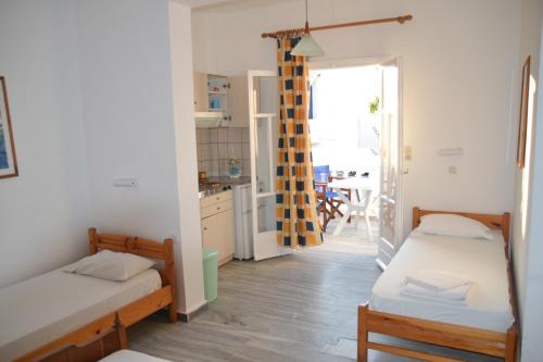 a small room with two beds and a kitchen at Artemis Pension in Ios Chora