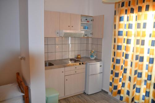 a small kitchen with a sink and a dishwasher at Artemis Pension in Ios Chora