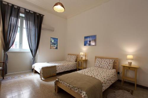 a bedroom with two beds and a window at Duchi in Palermo
