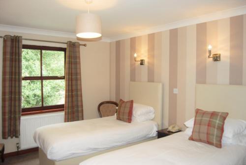 a hotel room with two beds and a window at Kingswood Hotel in Burntisland