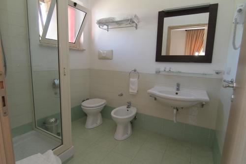a bathroom with a sink and a toilet and a mirror at Club Esse Sunbeach in Squillace