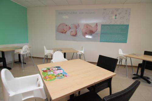 a classroom with tables and chairs and a baby picture on the wall at Club Esse Sunbeach in Squillace