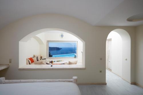 a bedroom with a window with a view of the ocean at Athermi Suites - Adults Only in Megalokhori