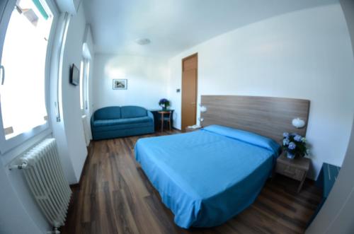 a bedroom with a blue bed and a couch at Hotel National in Zelbio