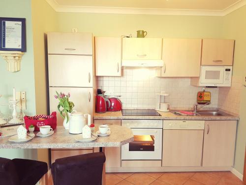 a kitchen with white cabinets and a counter top at Ferienwohnung Hugo in Zempin