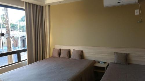 a hotel room with two beds and a window at Santa Clara Hotel e Restaurante in Sao Pedro do Sul