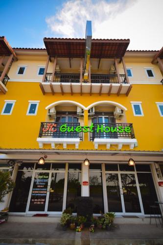 a yellow building with a sign on the front of it at JC Guesthouse @ Suratthani Airport in Surat Thani