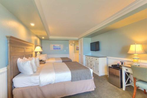 a hotel room with a large bed and a desk at Shutters on the Banks in Kill Devil Hills
