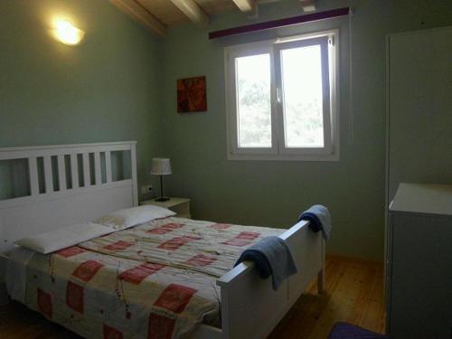 een slaapkamer met een bed en een raam bij Shambala Apartments in Liapades