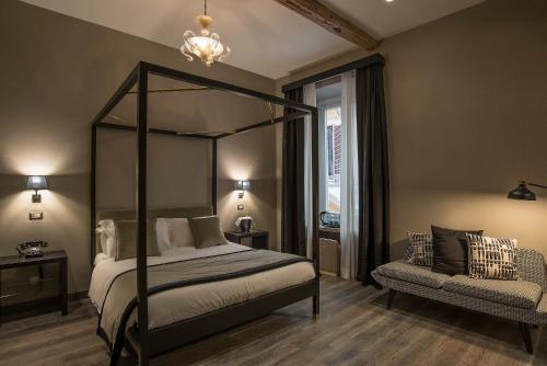 a bedroom with a canopy bed and a chair at Colonna Suite Del Corso in Rome