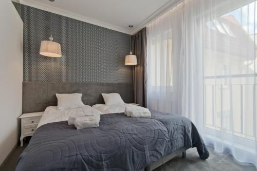 Apartamenty Gdańsk EU - Sopot Apartamenty في سوبوت: غرفة نوم عليها سرير وفوط