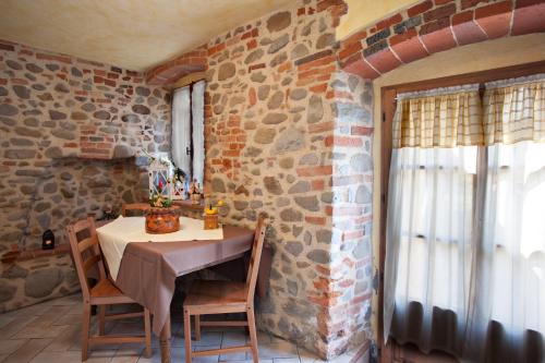 a dining room with a table and a brick wall at Agriturismo Il Piastrino in Vinci