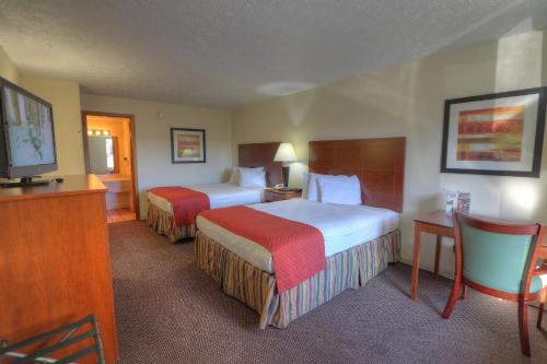 a hotel room with two beds and a flat screen tv at Days Inn By Wyndham Pigeon Forge South in Pigeon Forge