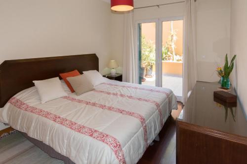 een slaapkamer met een groot bed en een groot raam bij Quinta da Torre in Câmara de Lobos
