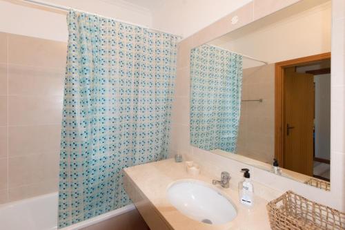 een badkamer met een wastafel en een spiegel bij Quinta da Torre in Câmara de Lobos