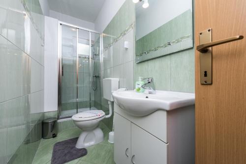 biała łazienka z umywalką i toaletą w obiekcie Kristina Apartments w mieście Zadar
