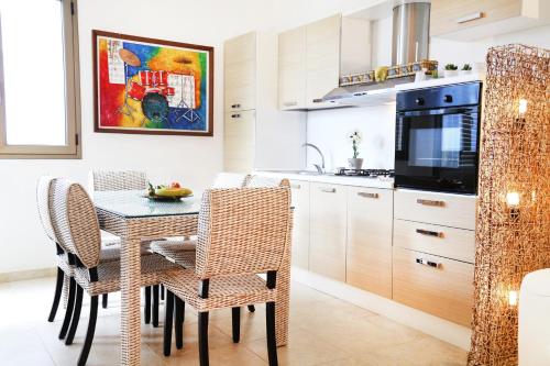 a kitchen and dining room with a table and chairs at Appartamenti le Conchiglie 1 by Ferrocino Holiday in Lido Conchiglie