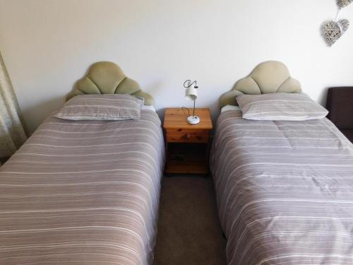 two beds sitting next to each other in a bedroom at Chelford Guesthouse in Marthall