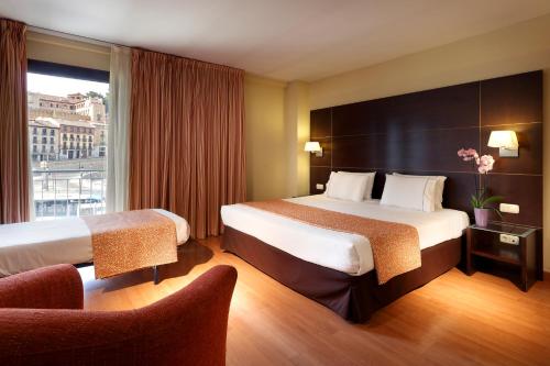 um quarto de hotel com duas camas e uma janela em Eurostars Plaza Acueducto em Segóvia