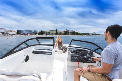 a man and woman on a boat in the water at Ilirija Resort Hotel Ilirija in Biograd na Moru
