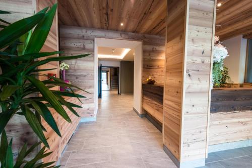 a hallway in a house with wooden walls and a plant at Hotel Fontanella in Molveno