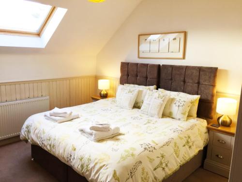 a bedroom with a large bed with two towels on it at Hillview Cottage in Glenlivet